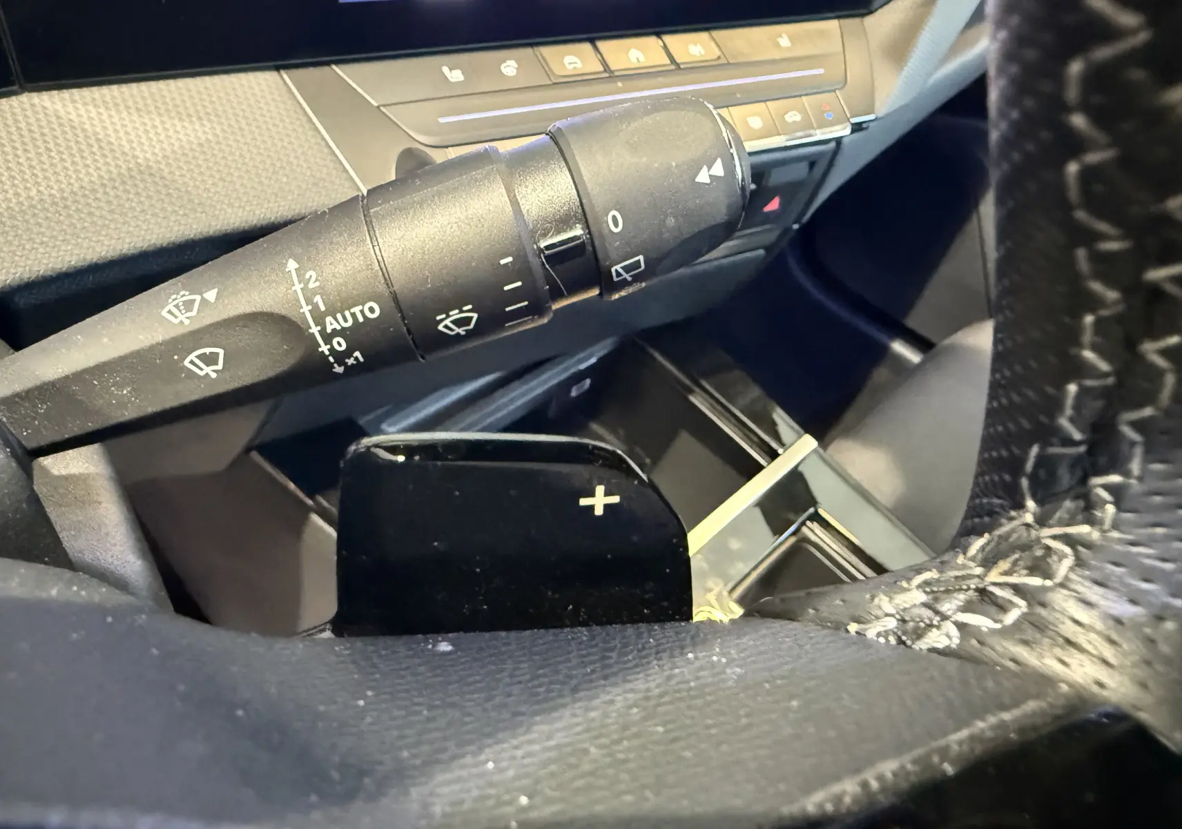 Gros plan sur le volant perforé et les commandes à gauche de l’Opel Astra Sports Tourer 2024, avec tableau de bord numérique.