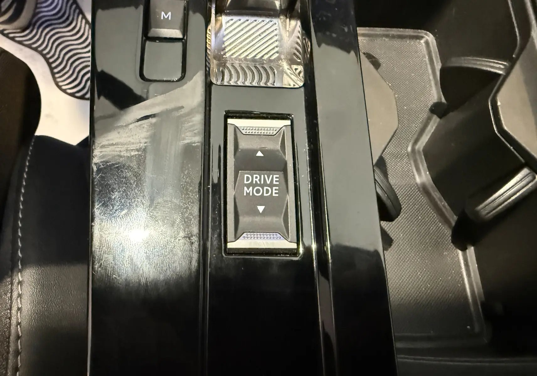Gros plan sur la console centrale noire brillante de l’Opel Astra Sports Tourer 2024 avec commandes de boîte auto à boutons.