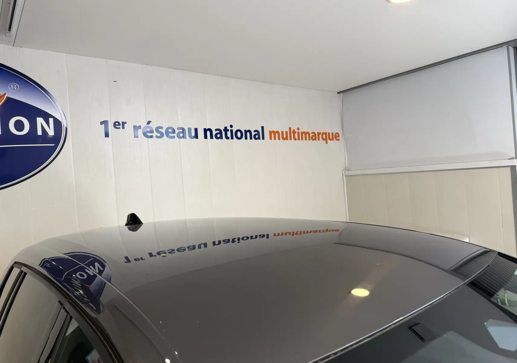 Toit gris métallisé d'une Opel Astra Sports Tourer 2024, vue en léger contre-plongée intérieure avec reflet mural.