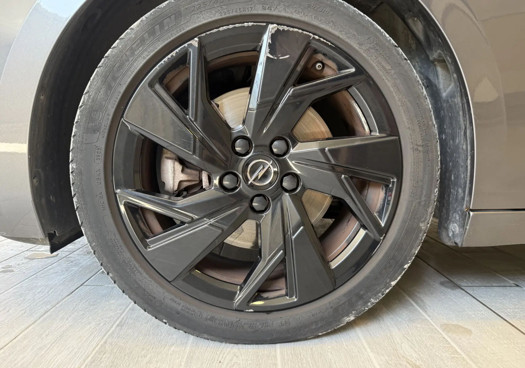 Gros plan sur la jante noire brillante de l’Opel Astra Sports Tourer gris 2024, mettant en valeur le logo central Opel.