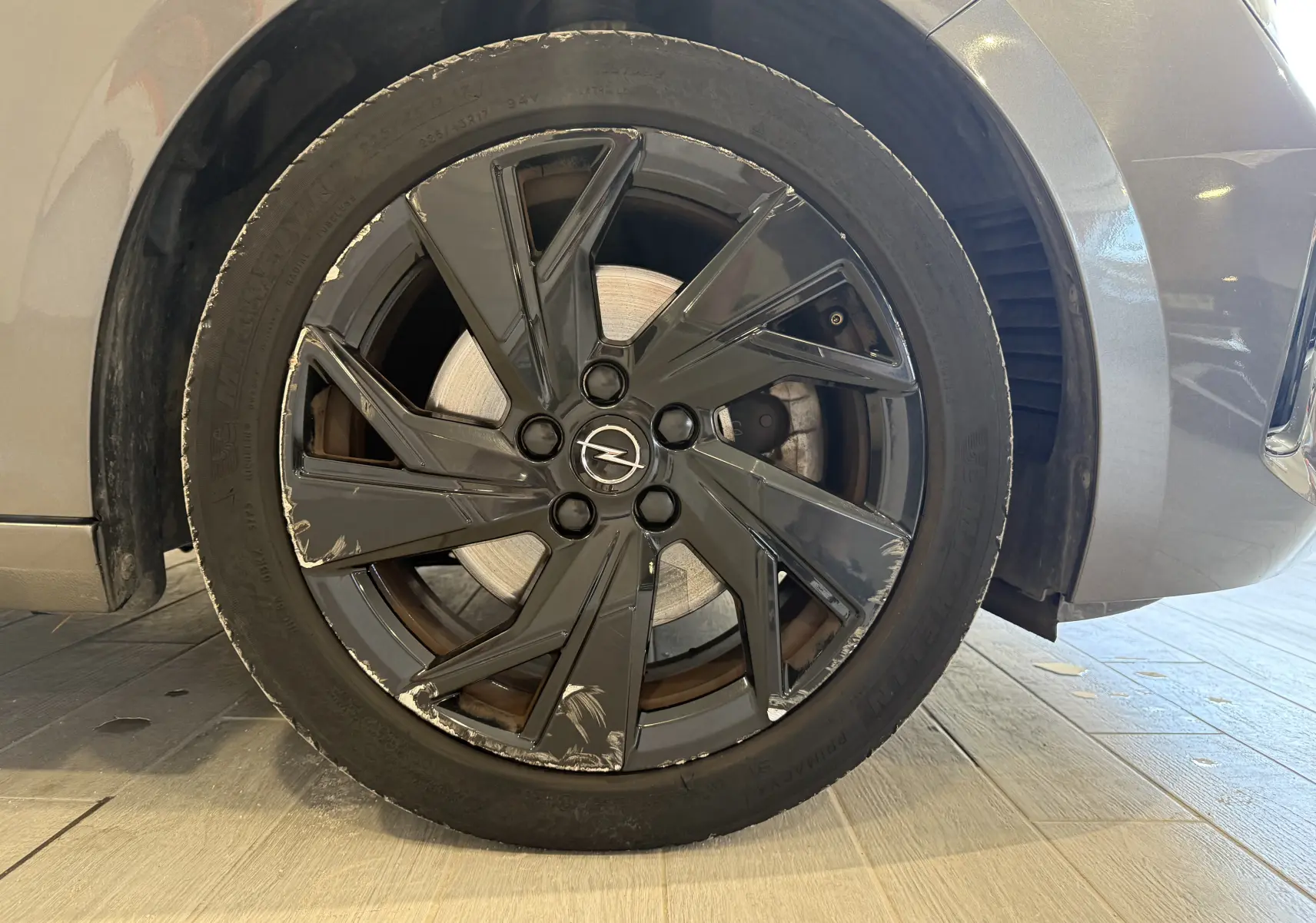 Gros plan sur la roue avant droite grise d’une Opel Astra Sports Tourer 2024 avec jante noire à éclats visibles.