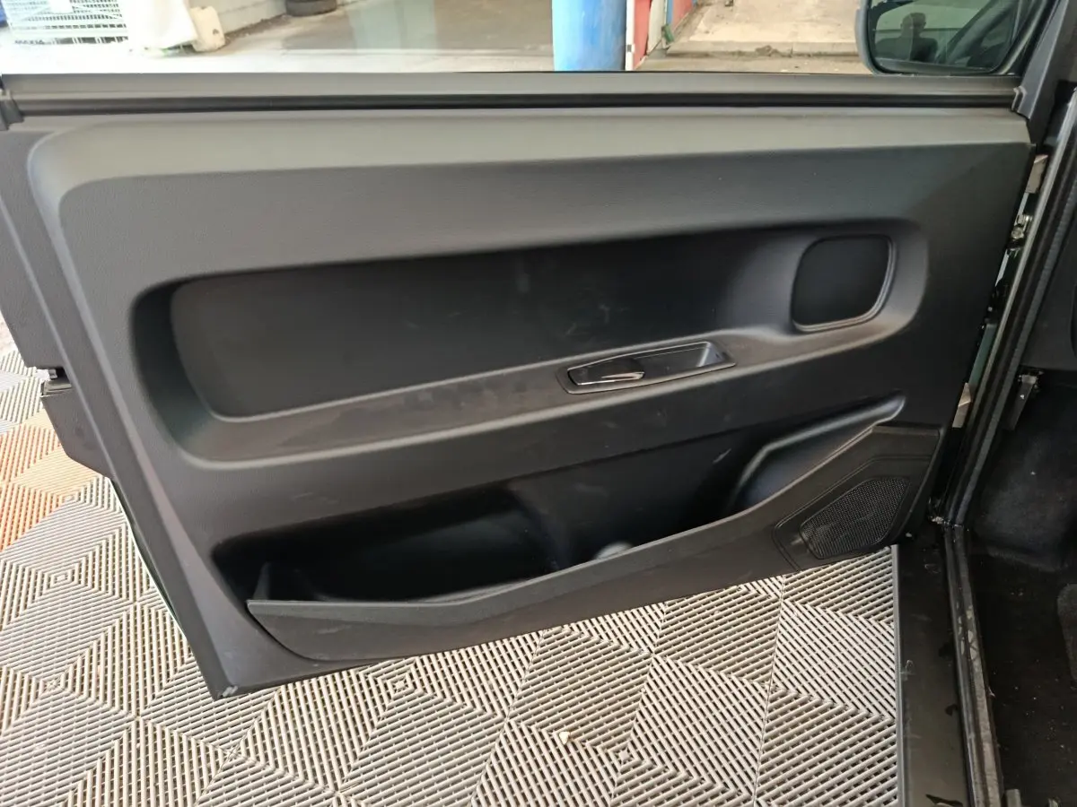 Détail de la porte intérieure côté gauche noire de l'AIXAM AMBITION Easy Chic thermique 2026, avec poignée intégrée.