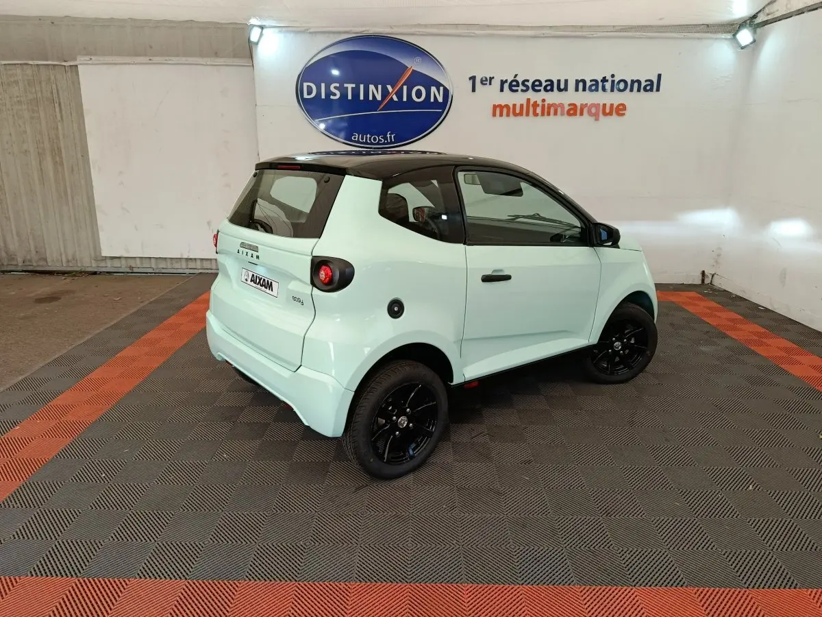 Vue 3/4 arrière droite d'une Aixam Ambition Easy Chic thermique 2026 vert clair avec toit noir et jantes noires.