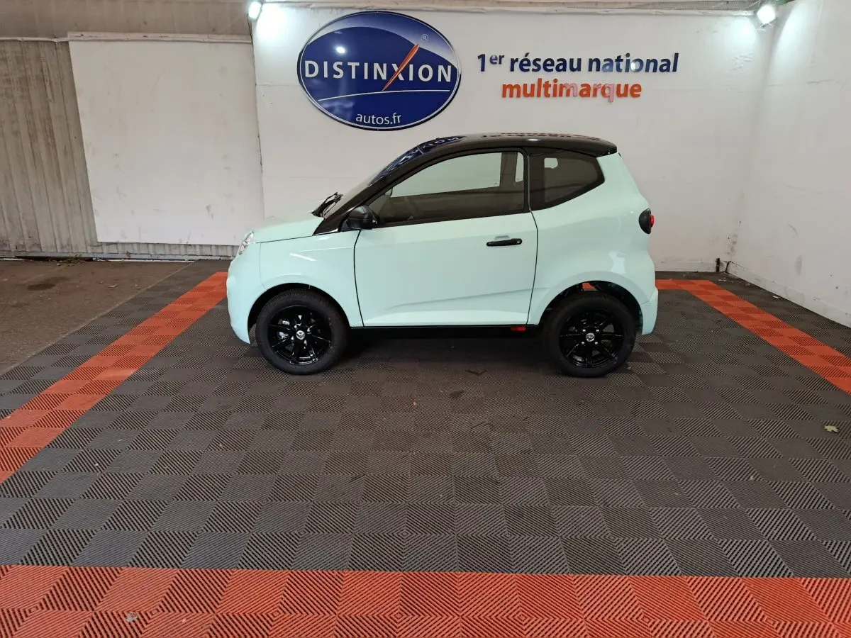 Vue de profil côté gauche de l'AIXAM AMBITION Easy Chic thermique S10-2 vert clair avec toit noir et jantes noires.