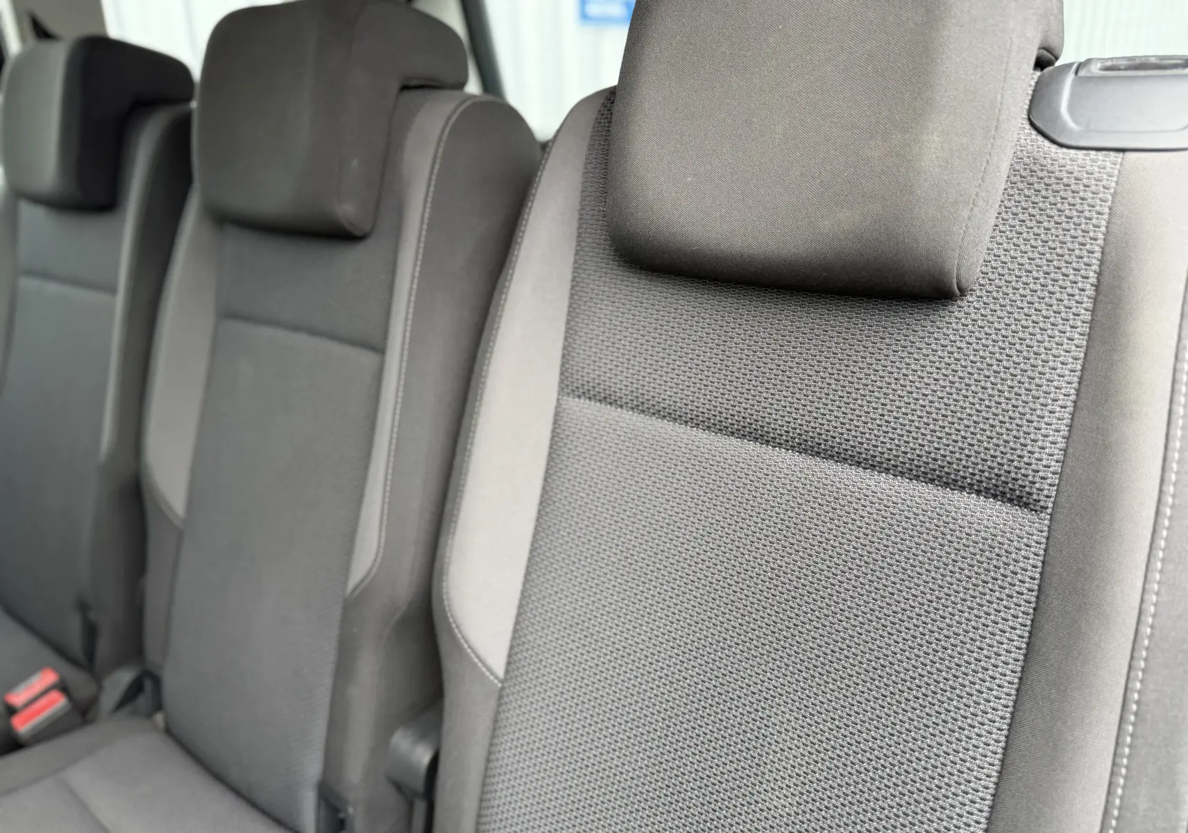 Gros plan sur les sièges arrière noirs en tissu du Volkswagen Touran 2017, version 1.6 TDI Trendline 7 places.