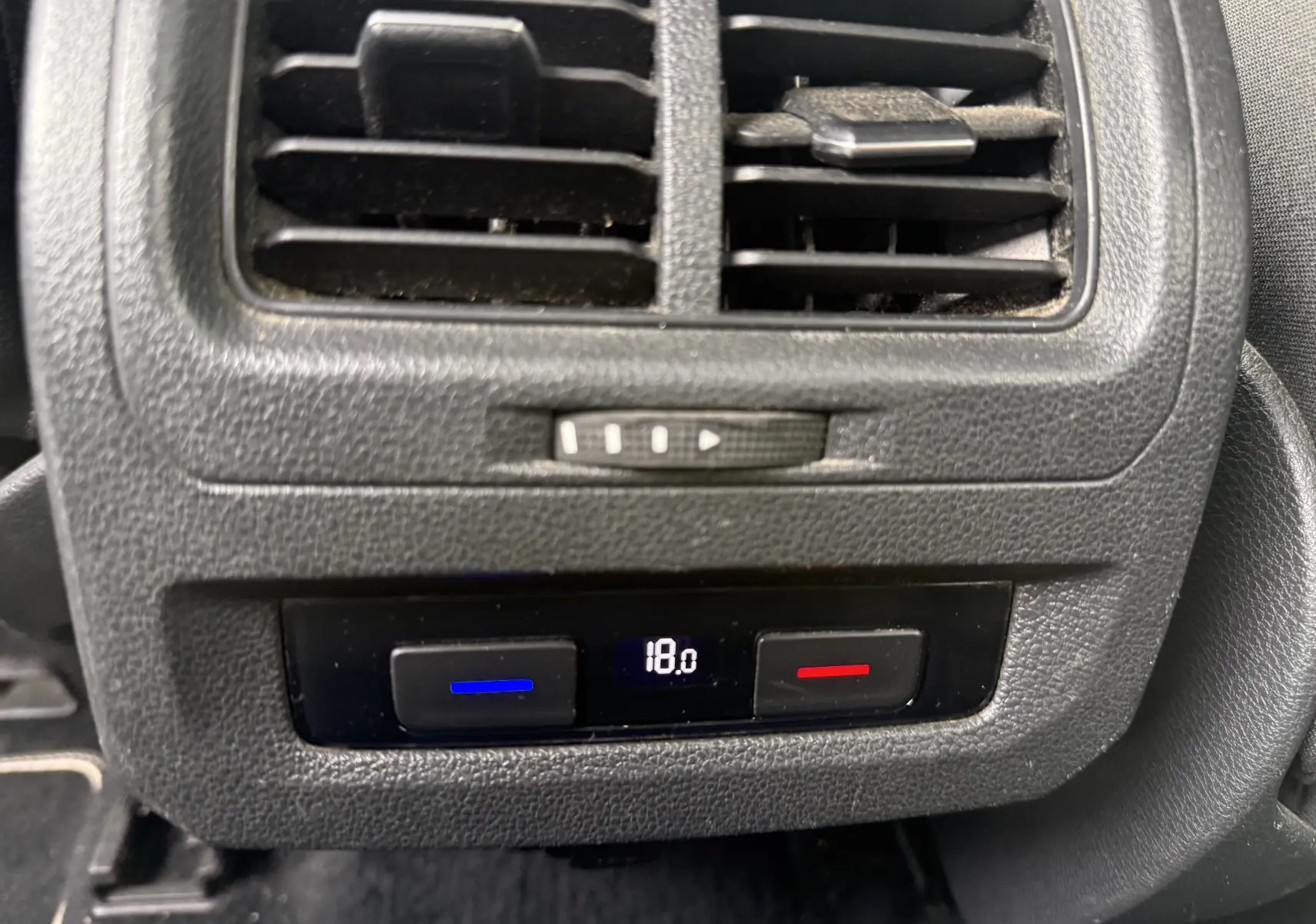 Détail de la ventilation arrière et commande de climatisation digitale à 18°C dans un Volkswagen Touran noir 2017.
