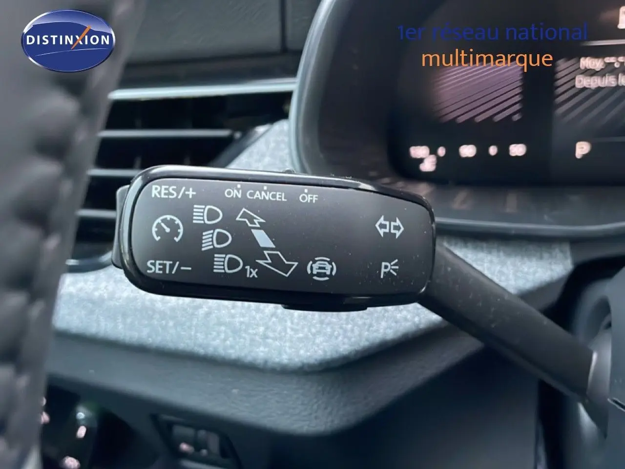 Gros plan sur la commande de régulateur de vitesse à gauche du volant dans l’habitacle gris graphite du Skoda Kamiq 2025.