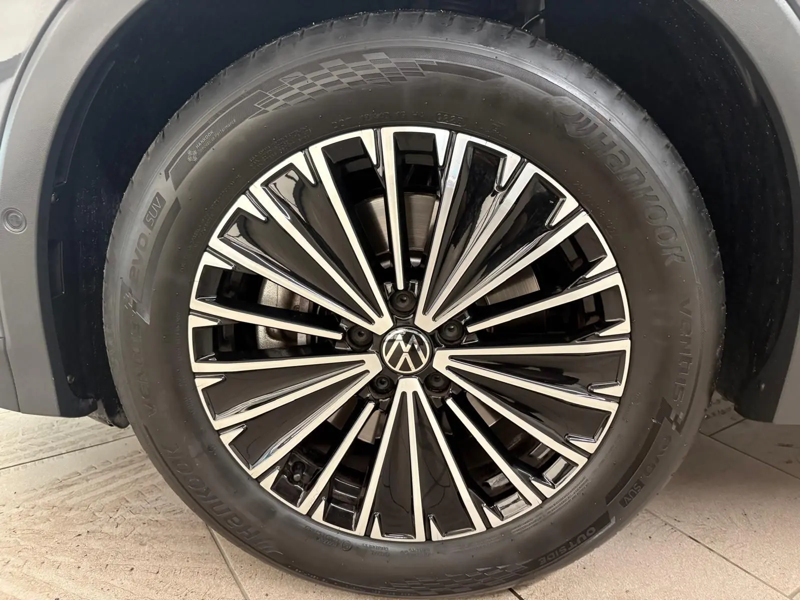 Gros plan sur la jante alliage bicolore du Volkswagen Tiguan Gris Dauphin, soulignant son design moderne.