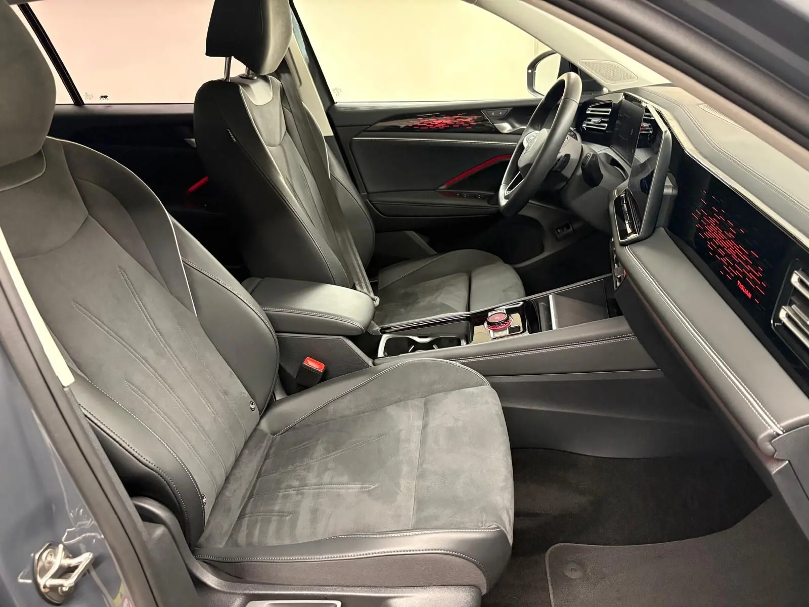 Vue intérieure côté conducteur du Volkswagen Tiguan 2025 gris Dauphin, sièges en cuir et alcantara avec tableau de bord numérique.