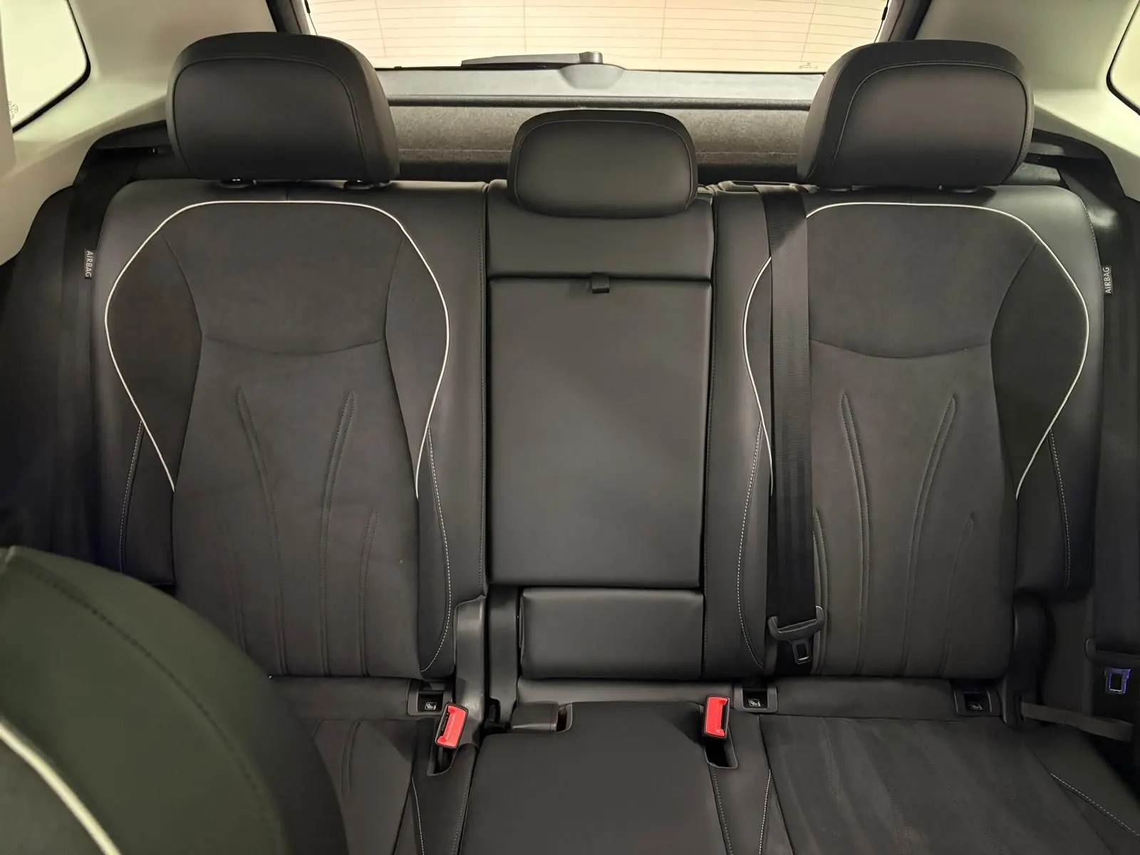 Vue intérieure des sièges arrière en cuir noir avec surpiqûres blanches du Volkswagen Tiguan 2.0 TDI 150 DSG7 Elegance 2025.