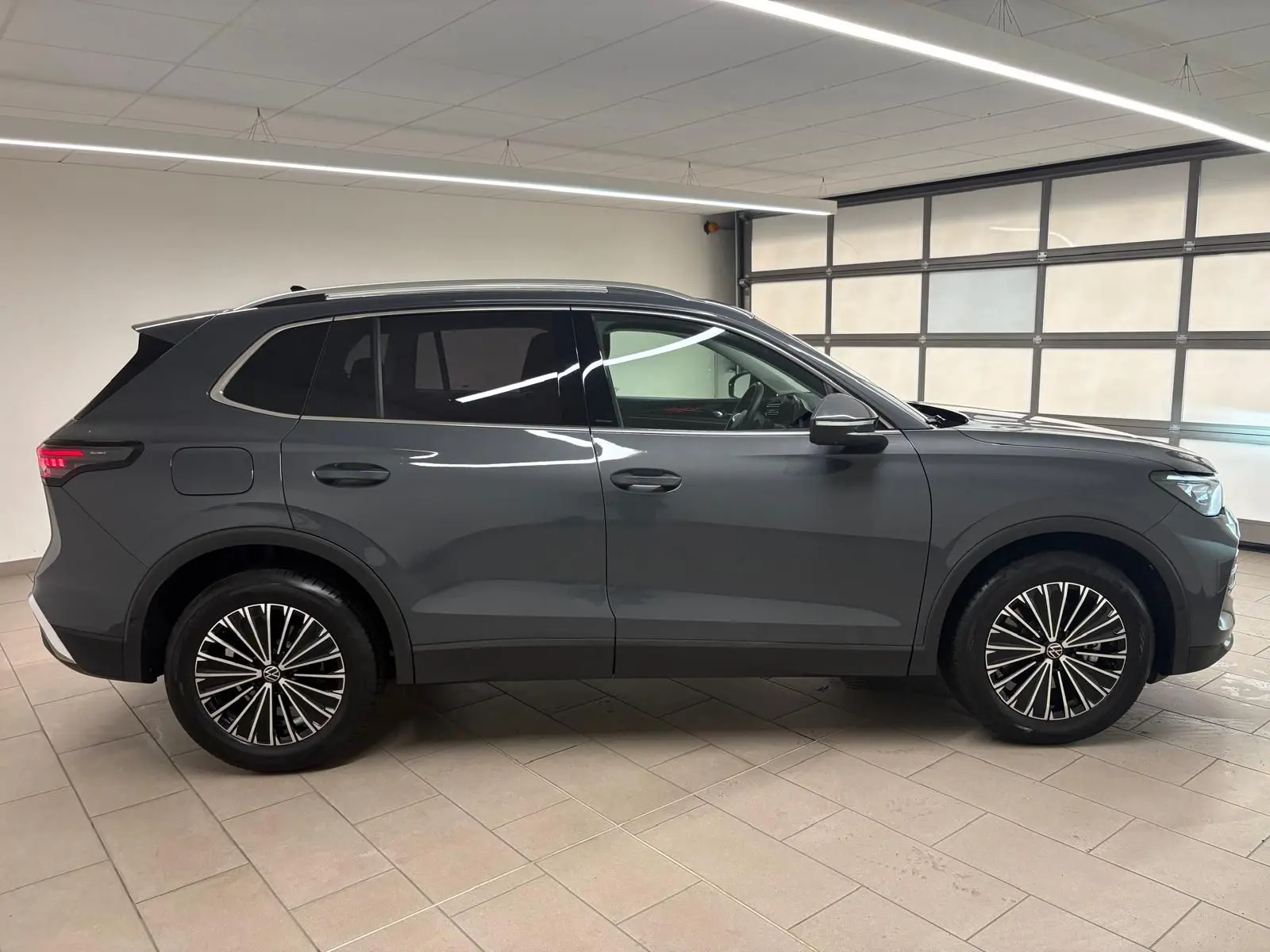 Vue de profil côté gauche du Volkswagen Tiguan 2.0 TDI 150 DSG7 Elegance gris dauphin métallisé en intérieur.