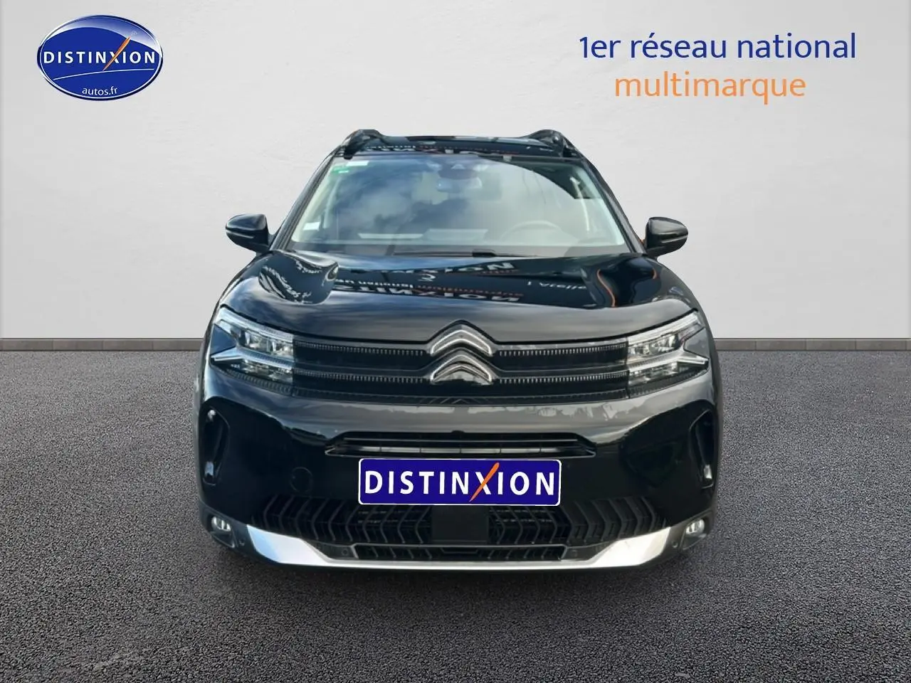 Vue avant d'un Citroën C5 Aircross noir 2025 avec calandre distinctive et phares LED allumés.