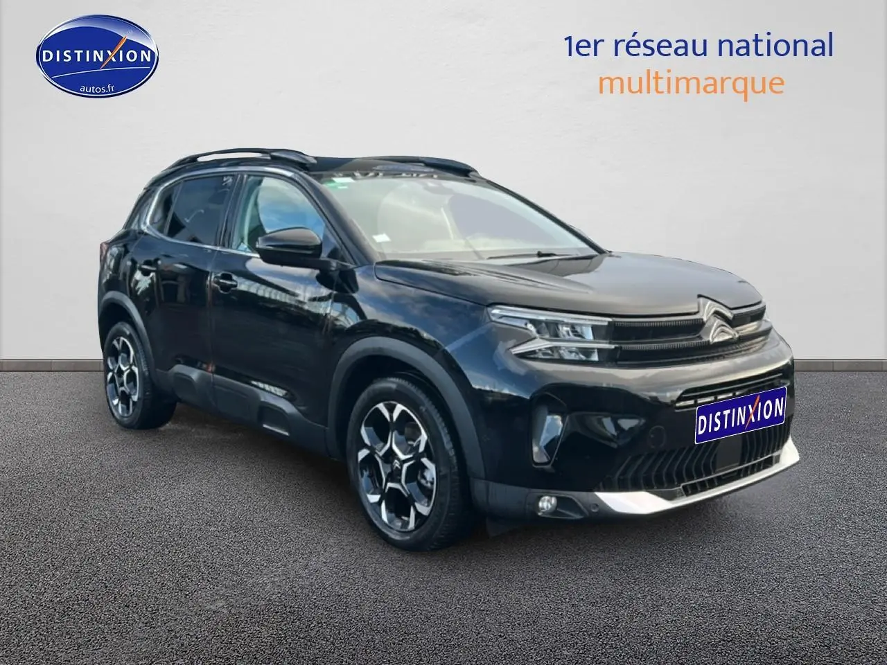 Citroën C5 Aircross noir en 3/4 avant droit, avec jantes alu et barres de toit visibles.