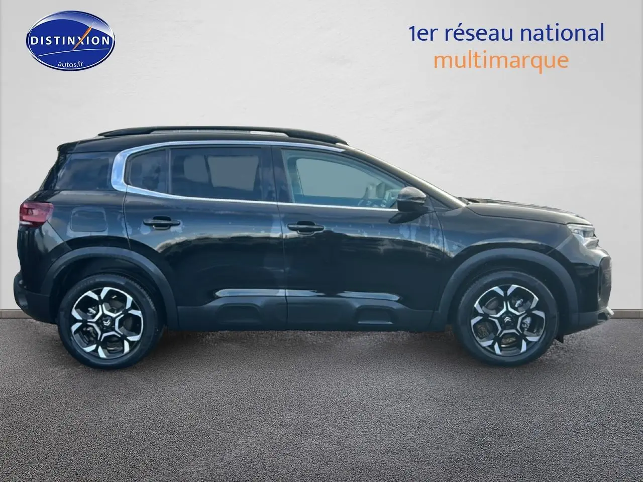 Vue latérale droite du Citroën C5 Aircross noir 2025 avec jantes alliage et barres de toit visibles.