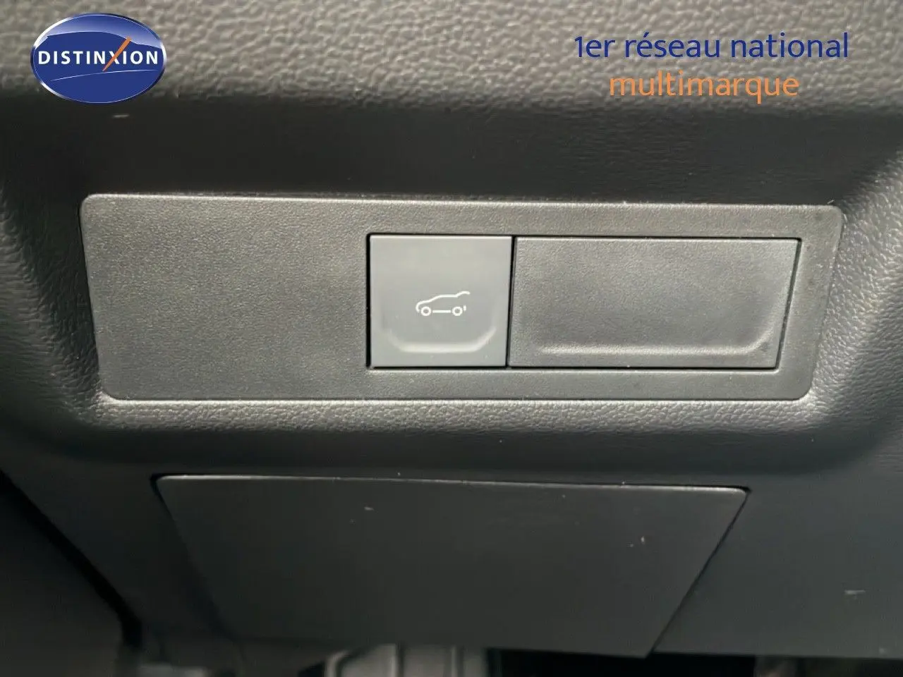 Bouton d'ouverture du coffre sur le tableau de bord intérieur d'une Renault Symbioz bleu iron metal, version 2025.