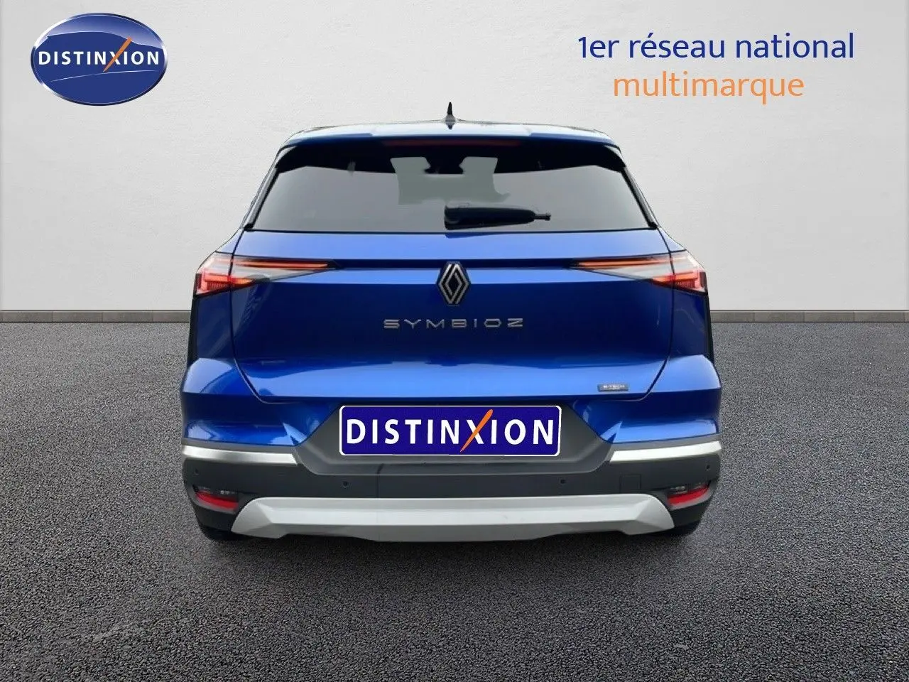 Vue arrière d'une Renault SYMBIOZ bleu iron metal 2025 avec feux arrière fins et logo central distinctif.