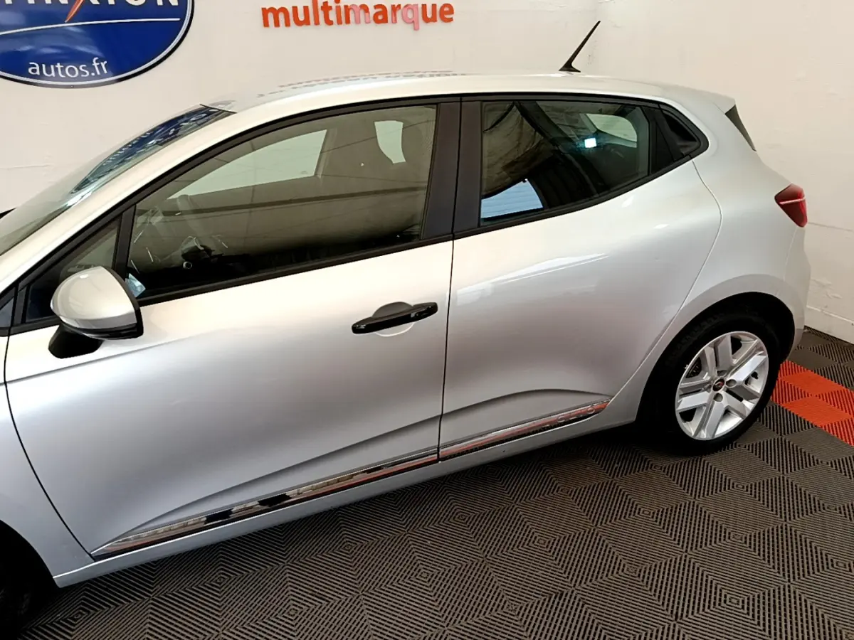 Vue latérale droite d'une Renault Clio Business TCe 100 gris clair, avec jantes alliage et poignées noires.
