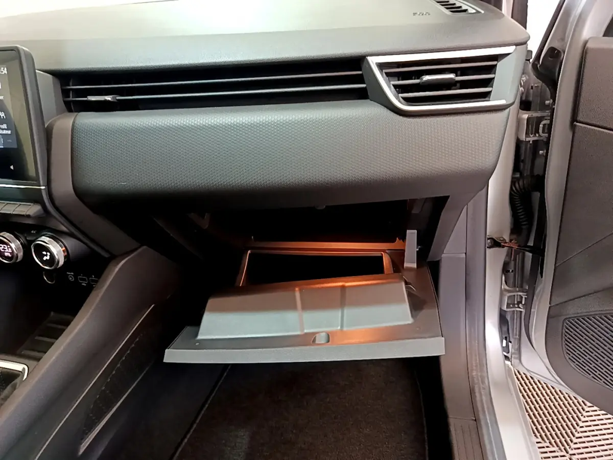 Vue intérieure côté passager de la Renault Clio Business 2020, boîte à gants ouverte avec éclairage intérieur visible.