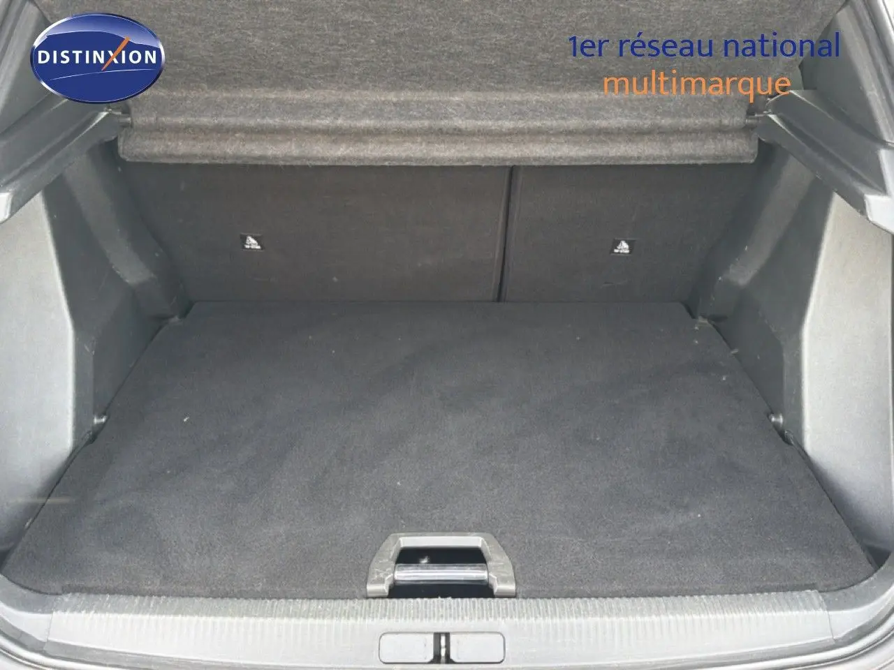 Coffre ouvert vu de l'arrière d'un Peugeot 2008 noir perle métal, montrant un espace de chargement propre et vide.