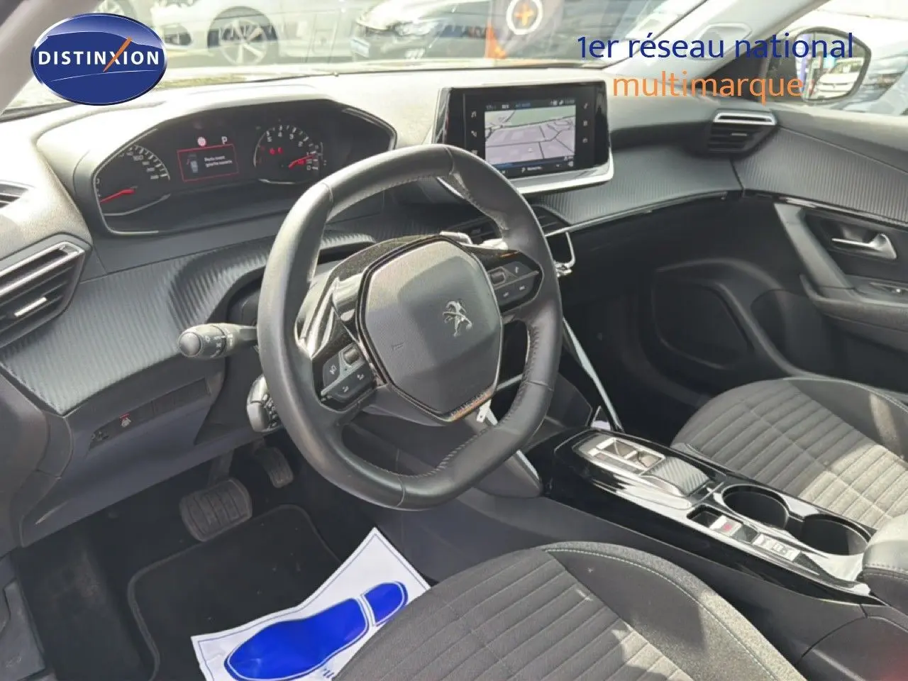 Vue intérieure côté conducteur du Peugeot 2008 noir perle métal, avec volant compact et écran tactile central.