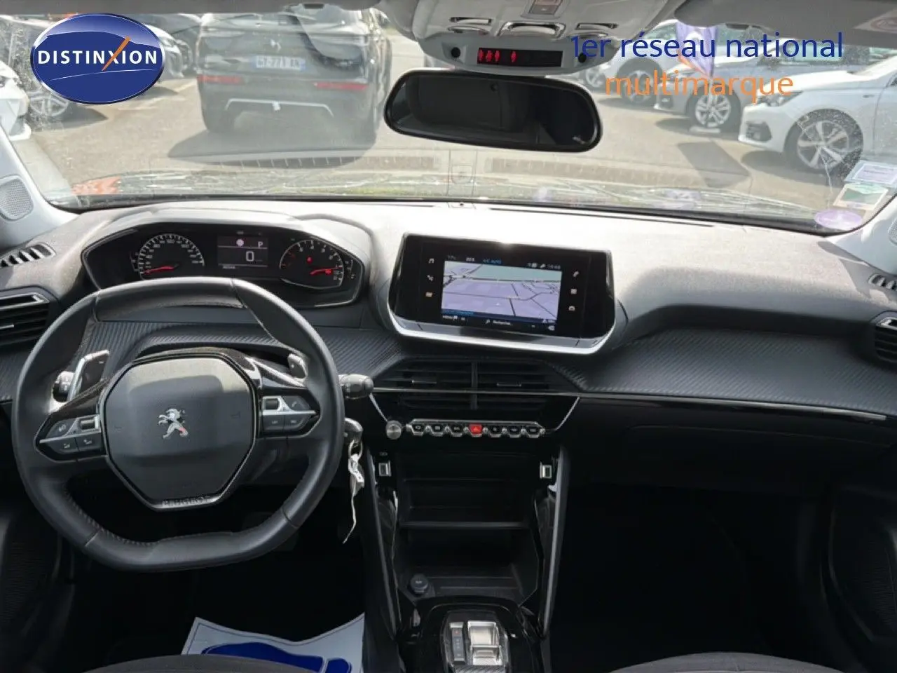 Vue intérieure avant du Peugeot 2008 noir perle métal 2022, tableau de bord moderne avec écran tactile et volant compact.