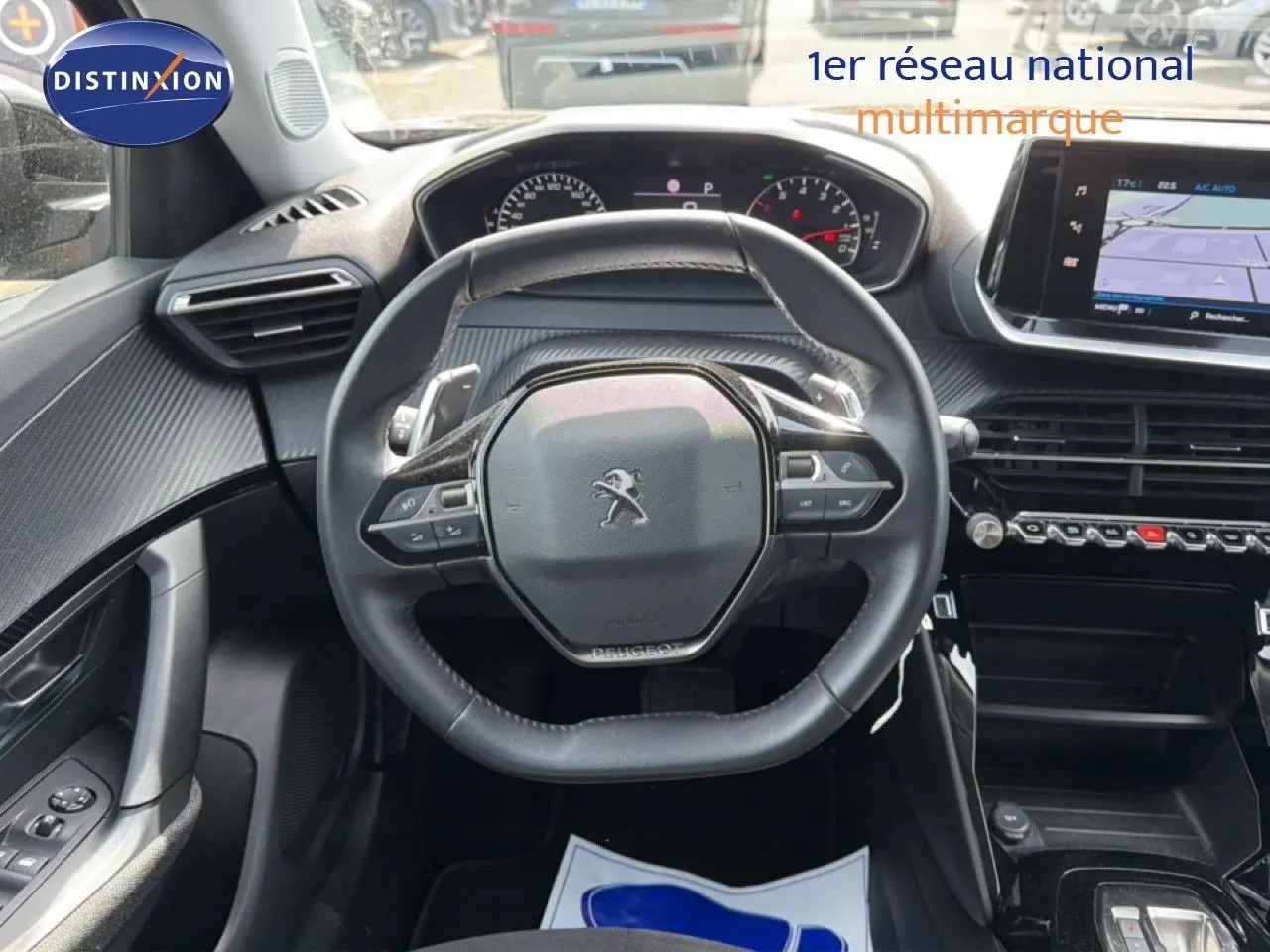 Vue intérieure centrée sur le volant compact de la Peugeot 2008 2022 avec tableau de bord et écran tactile visibles.