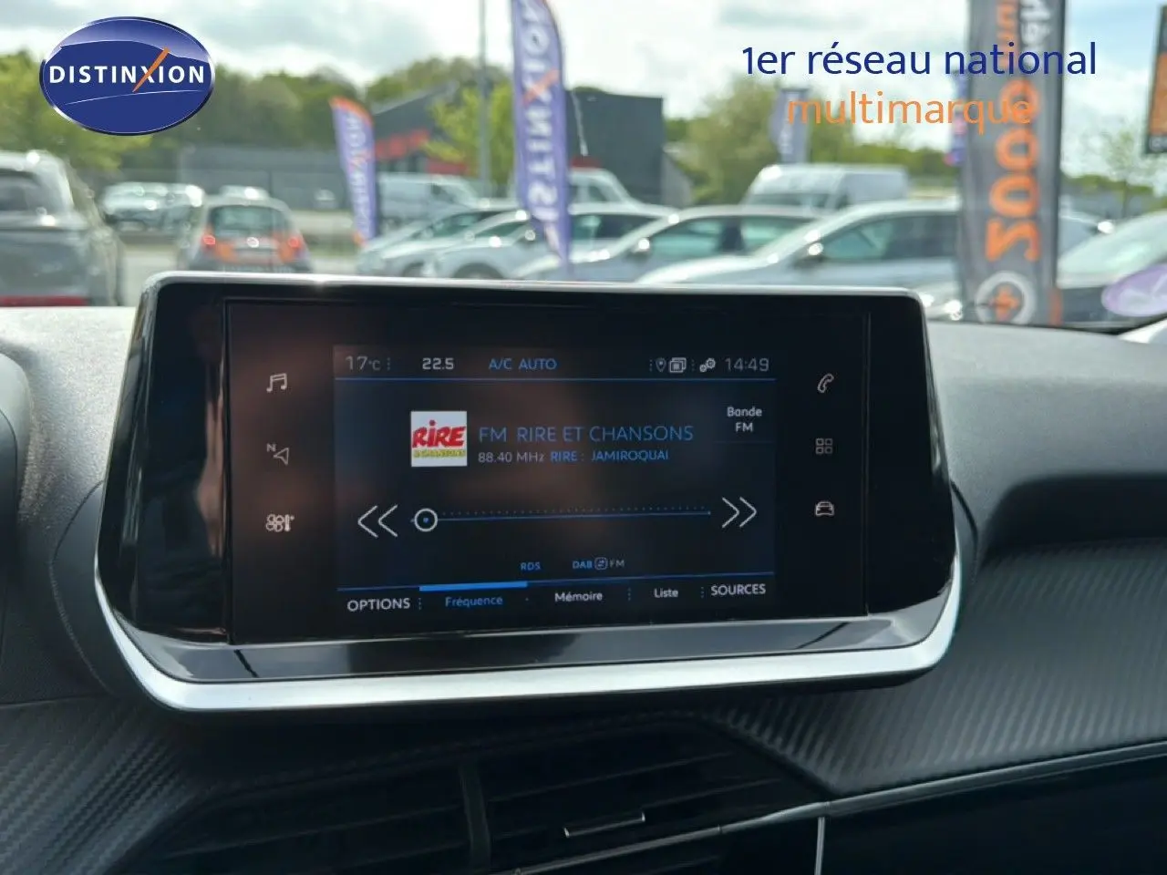 Écran tactile central du tableau de bord de la Peugeot 2008 noir perle métal, affichant une radio FM en extérieur.