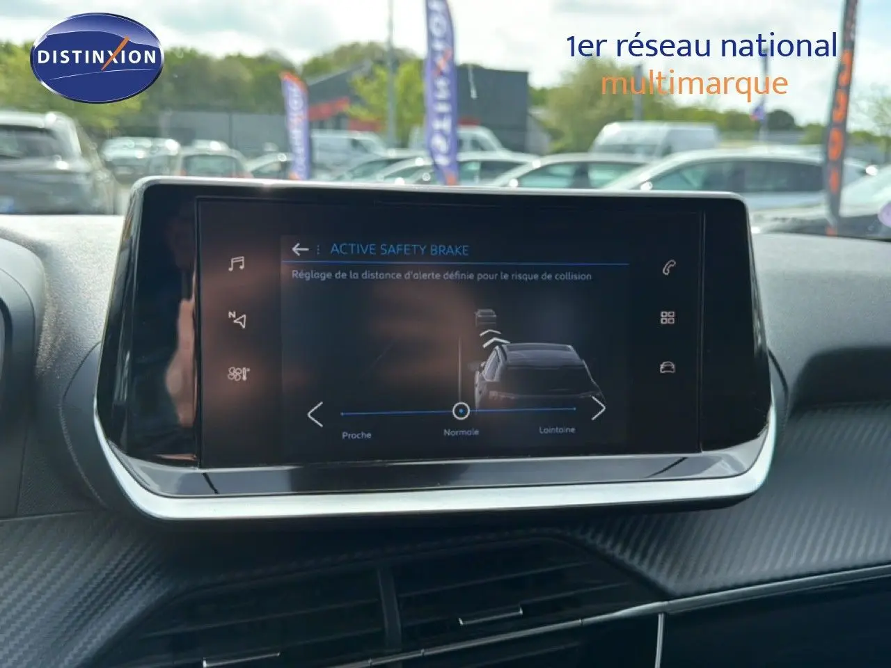 Écran tactile central du Peugeot 2008 noir perle métal de 2022 affichant le réglage de l'Active Safety Brake en extérieur.