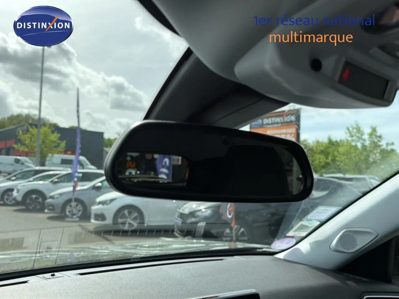 Vue intérieure centrée sur le rétroviseur intérieur d'une Peugeot 2008 noir perle métal, avec tableau de bord partiellement visible.