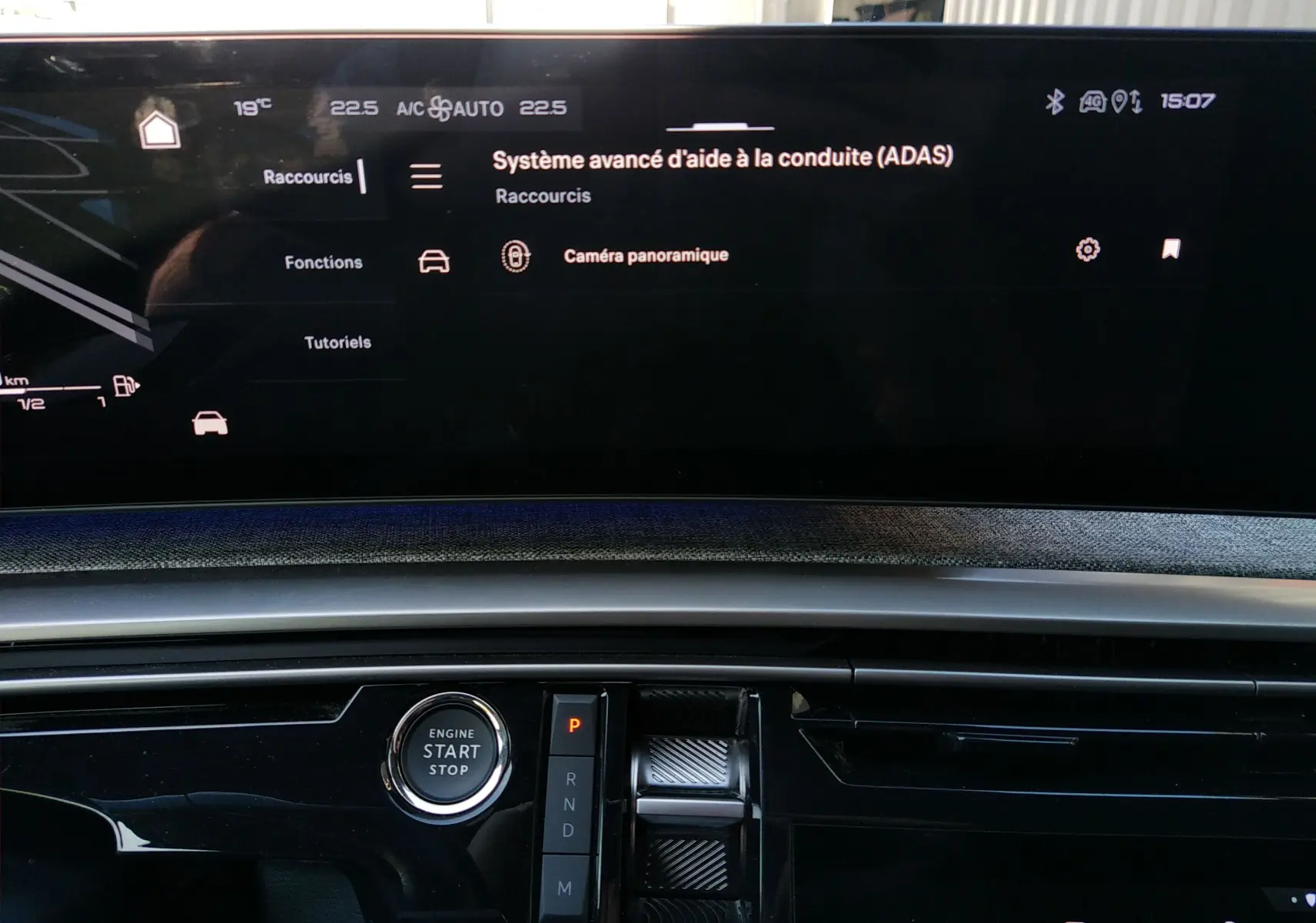 Vue rapprochée de l’écran tactile et console centrale du Peugeot 3008 Hybrid gris titane, avec bouton start/stop et commandes de boîte auto.