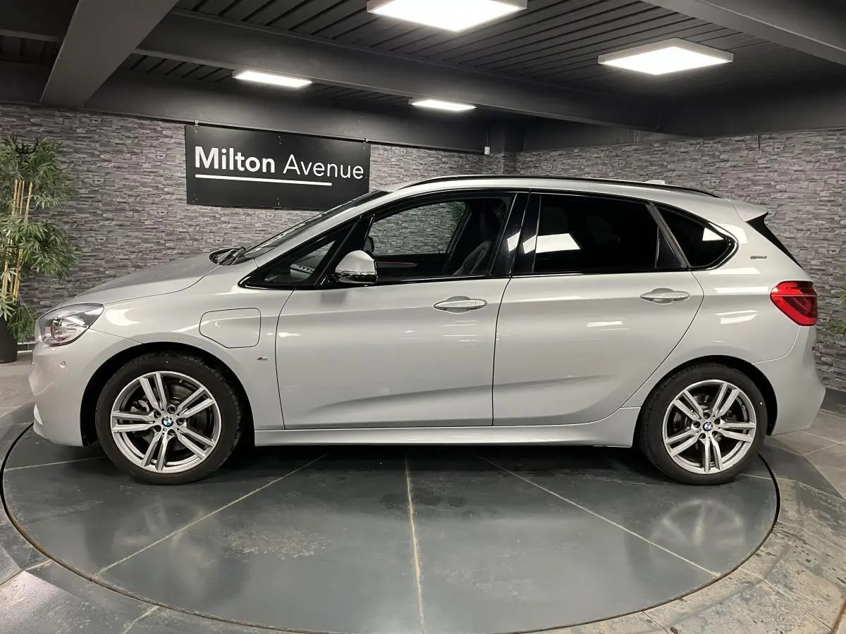 BMW Série 2 225xe Active Tourer gris vue de profil côté gauche, avec jantes alliage et badge eDrive visible.