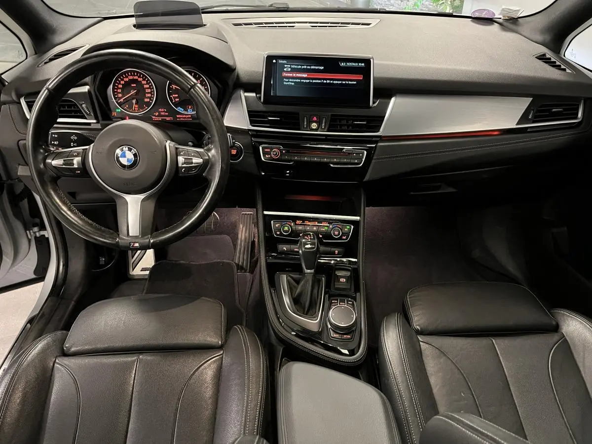 Vue intérieure avant de la BMW Série 2 225xe M Sport 2018, avec tableau de bord noir et volant cuir M.