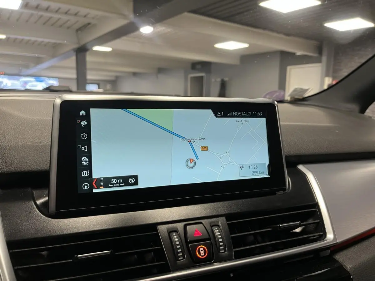 Écran de navigation central intérieur de BMW Série 2 gris, avec affichage carte et commandes autour.