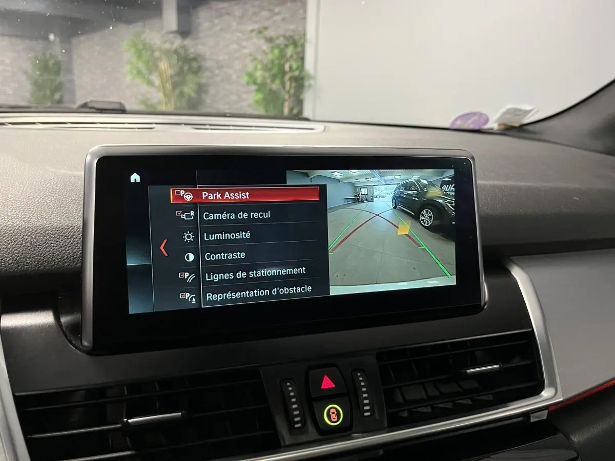 Écran intérieur de la BMW Série 2 225xe gris montrant la caméra de recul et l'assistance au stationnement.