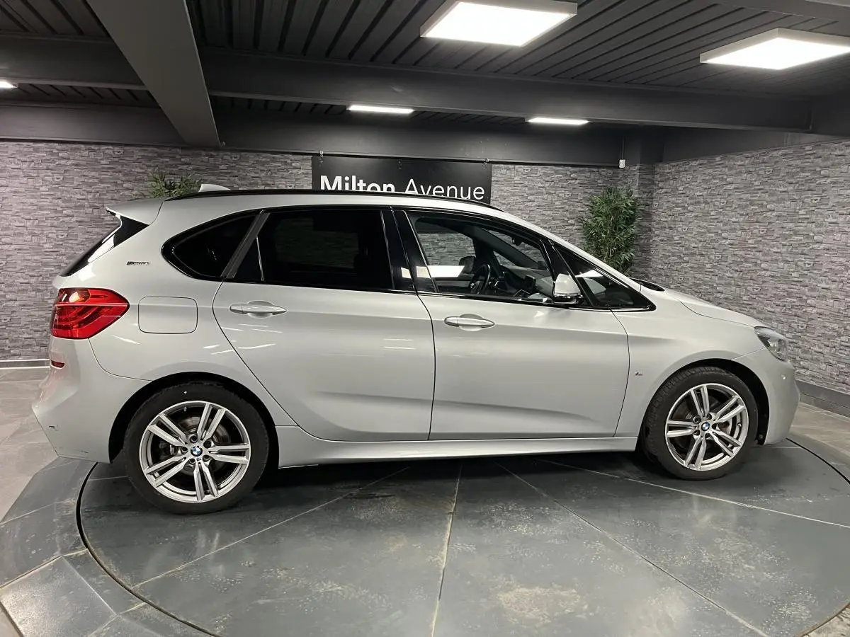 BMW Série 2 225xe Active Tourer gris vue de profil côté gauche en intérieur avec jantes alliage M Sport.