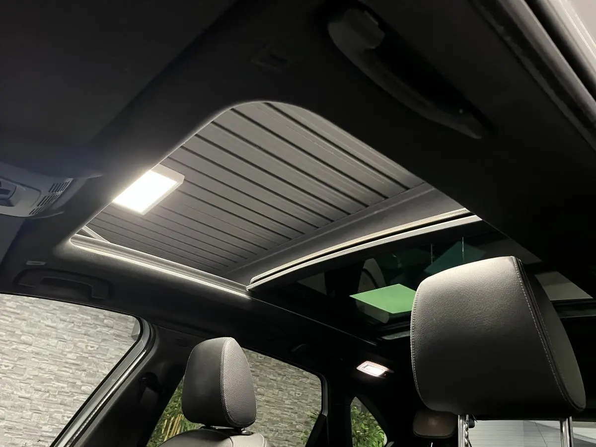 Vue intérieure du toit ouvrant panoramique en verre et des sièges avant en cuir noir de la BMW Série 2 225xe Active Tourer M Sport.