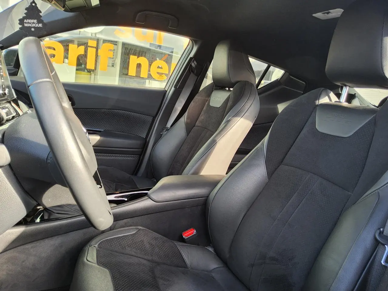 Vue intérieure côté conducteur du Toyota C-HR 2.0 Hybrid 2020, sièges sport cuir et alcantara noirs avec surpiqûres.