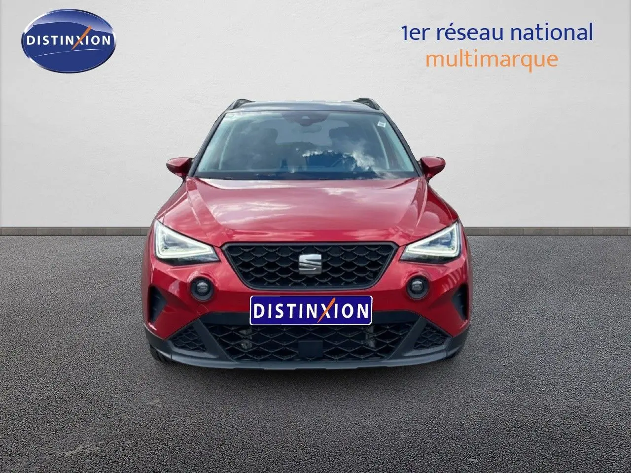Vue avant d'un SEAT Arona rouge Désir Métal avec toit noir, calandre noire et feux LED allumés.