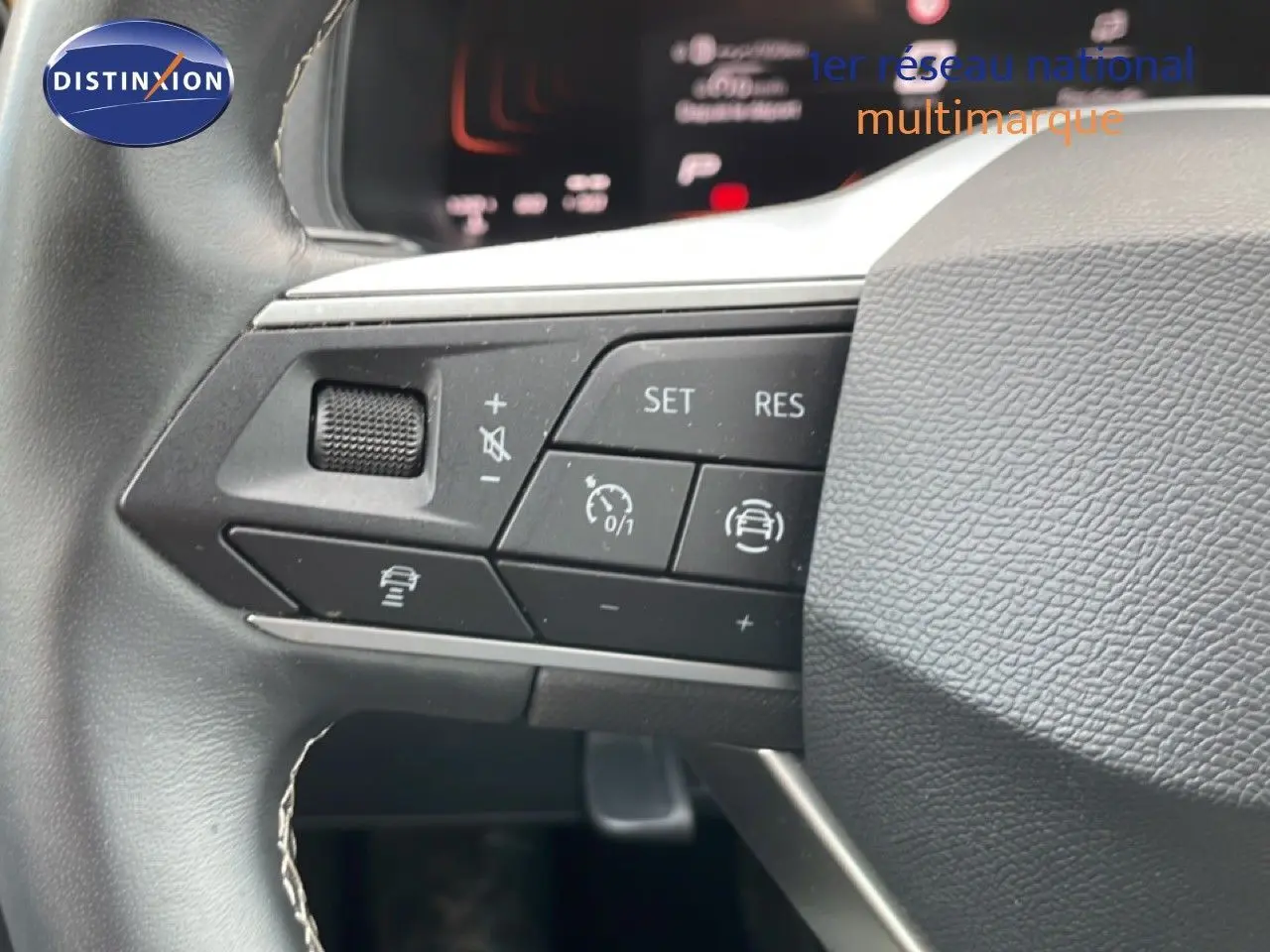 Gros plan sur les commandes au volant du SEAT Arona 2025, mettant en valeur les boutons de régulateur et d'assistance.