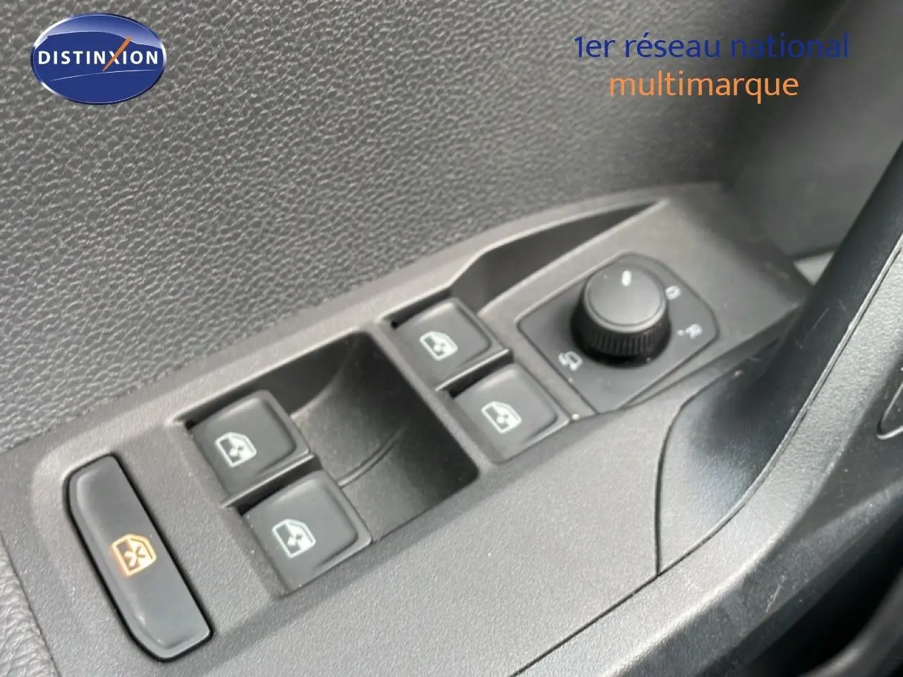 Gros plan sur les commandes des vitres électriques et réglage des rétroviseurs côté conducteur d'un SEAT Arona rouge toit noir.