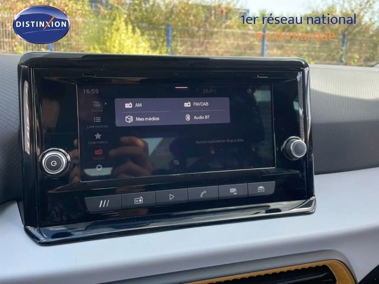 Écran tactile central du tableau de bord du SEAT Arona 2025, affichant les options audio avec reflet extérieur.