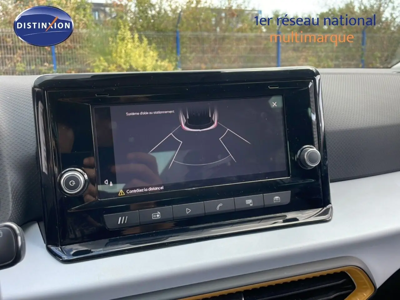 Écran tactile du système d'aide au stationnement dans l'habitacle d'une SEAT Arona rouge avec toit noir.
