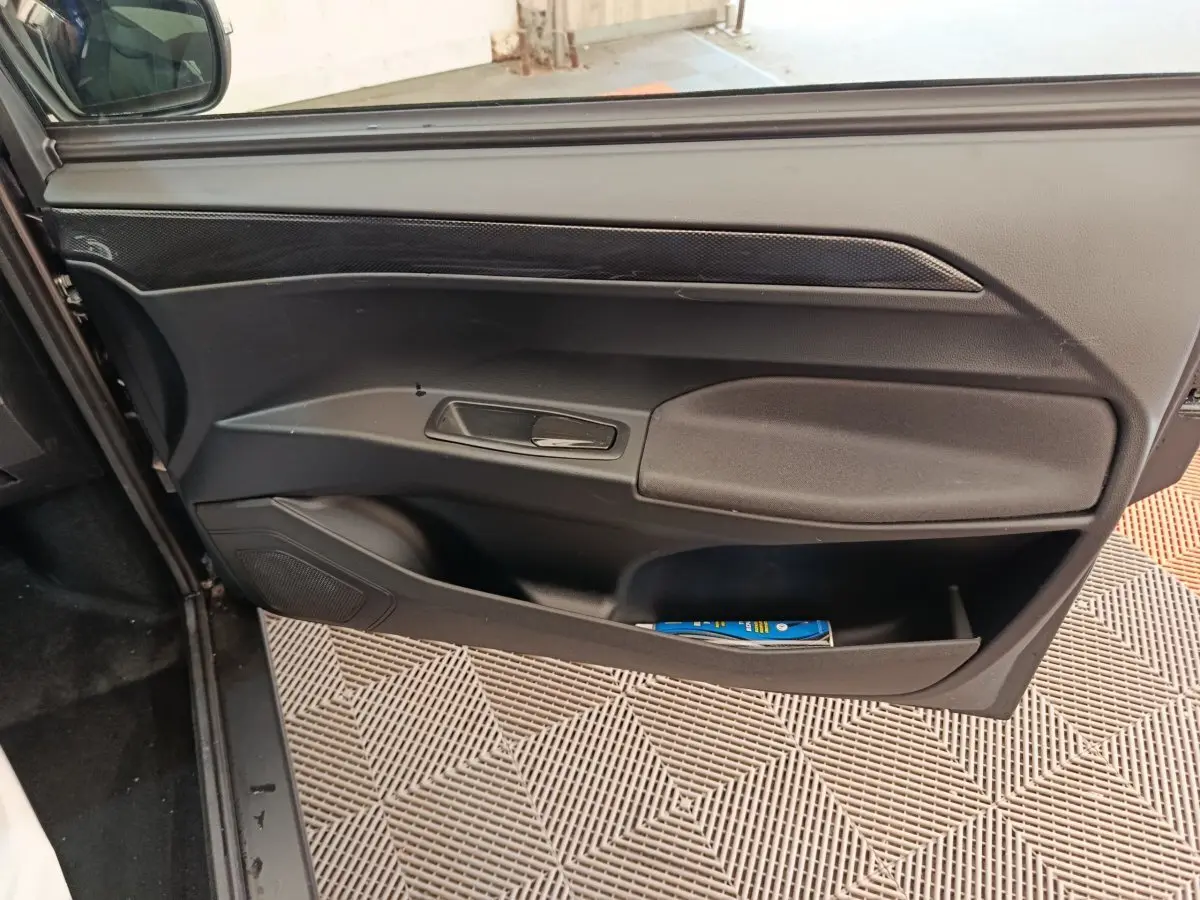 Vue rapprochée de la porte côté conducteur noire de l'AIXAM AMBITION 0.5 CITY COUPE GTI avec poignée intégrée.