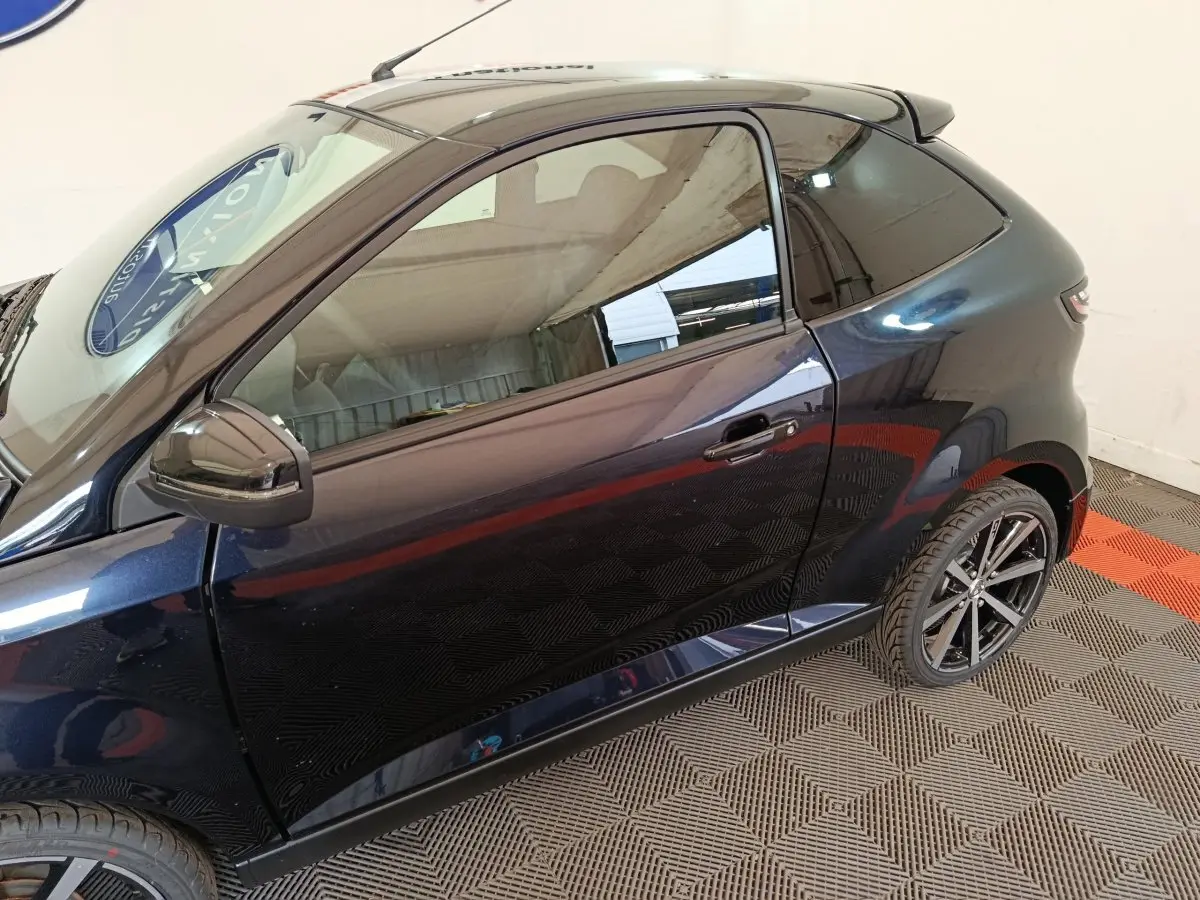 Vue latérale gauche d'une Aixam Ambition 0.5 City Coupe GTI noire avec rétroviseur conducteur et jantes noires.