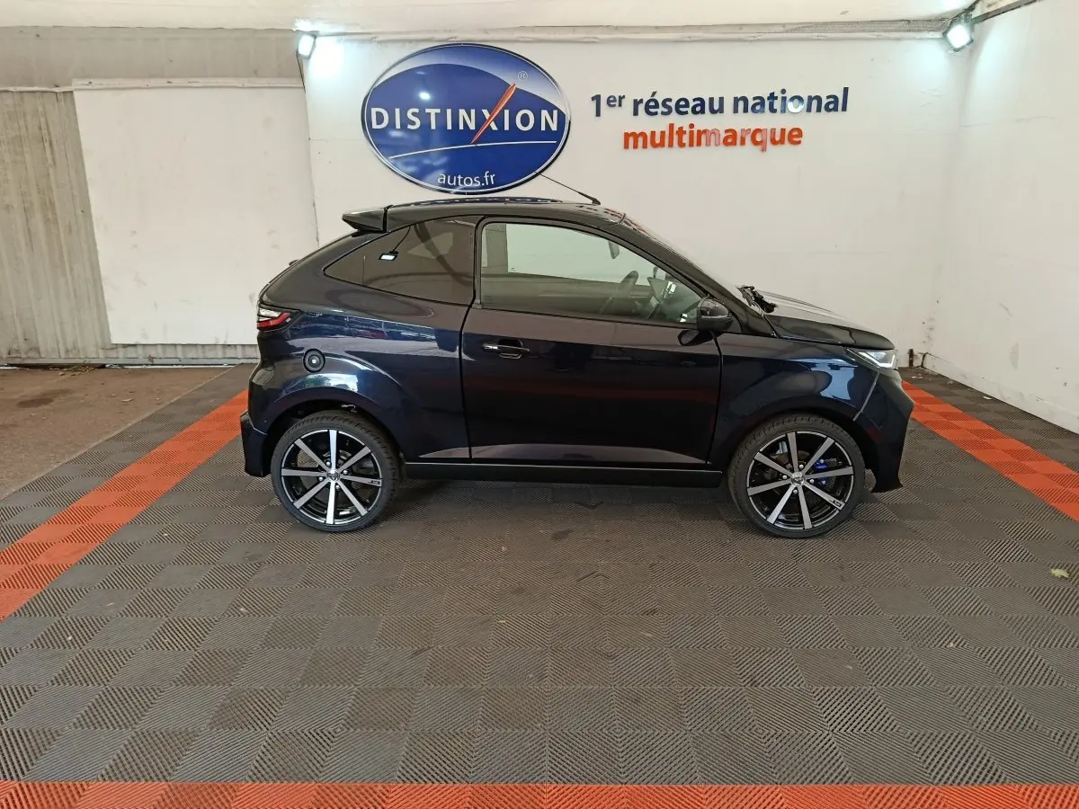 Vue de profil côté gauche d'une Aixam Ambition 0.5 City Coupe GTI noire avec jantes alliage et rétroviseur conducteur.