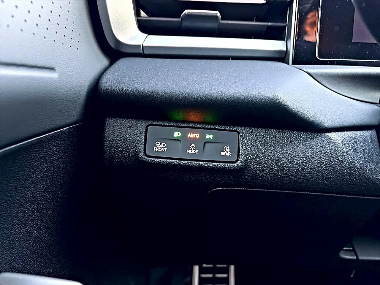 Détail du tableau de bord noir du Volkswagen T-Roc 1.5 R-Line 2026 avec commandes d'éclairage automatiques.