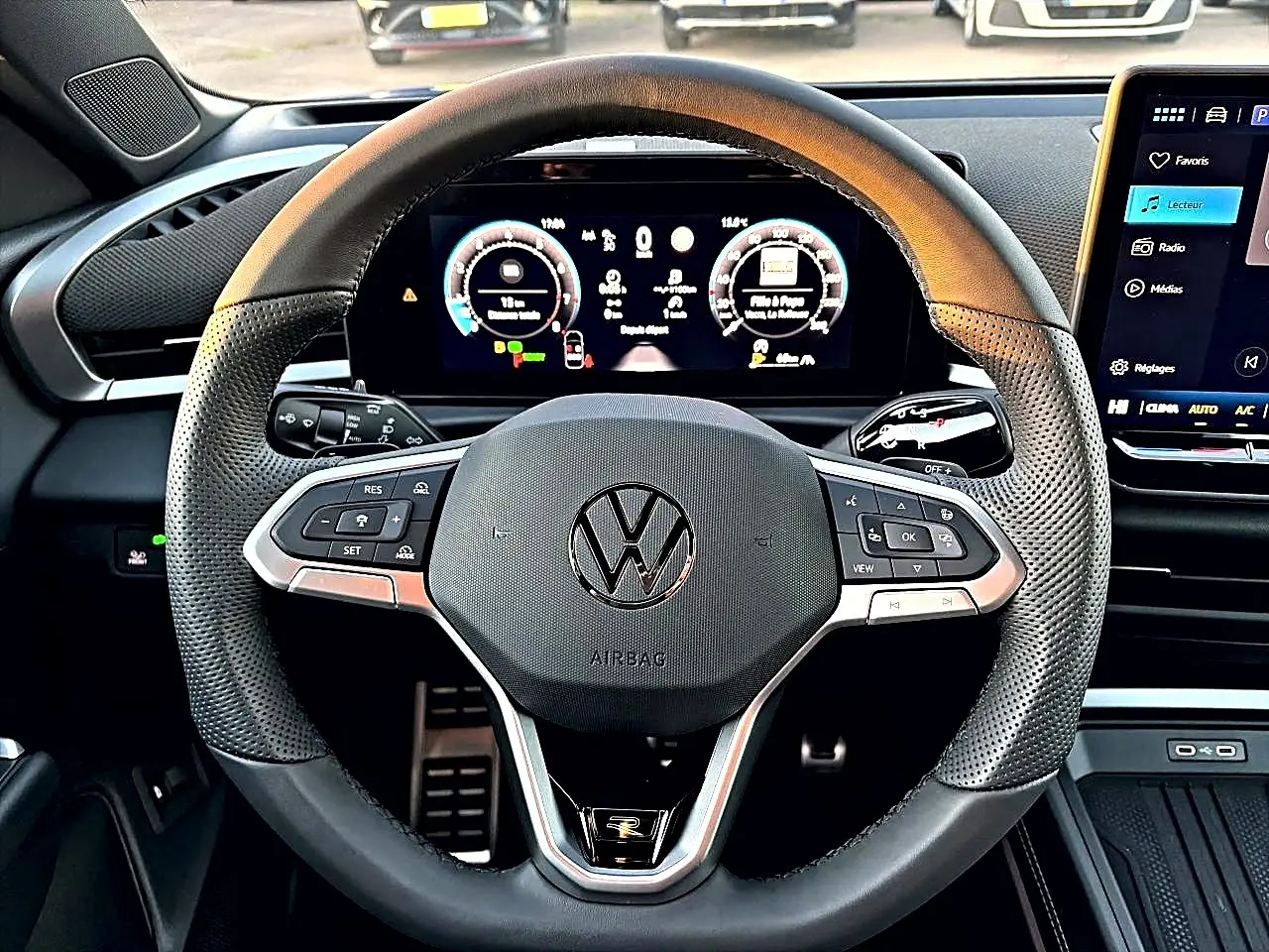 Vue rapprochée du volant sport en cuir noir perforé du Volkswagen T-Roc 2026 avec tableau de bord numérique et écran tactile.