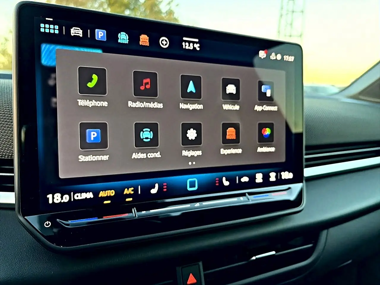 Écran tactile central du Volkswagen T-Roc 2026 affichant les menus de navigation et médias, intérieur noir.