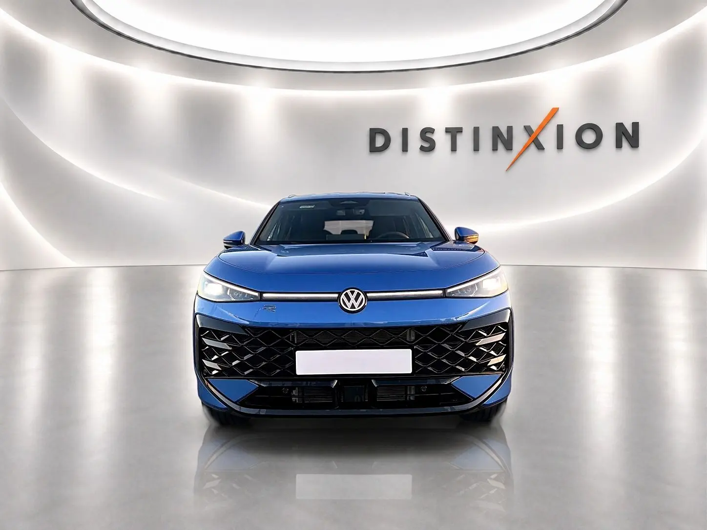 Vue frontale du Volkswagen T-Roc 1.5 etsi 150 R-Line bleu céleste avec calandre noire et logo VW lumineux.
