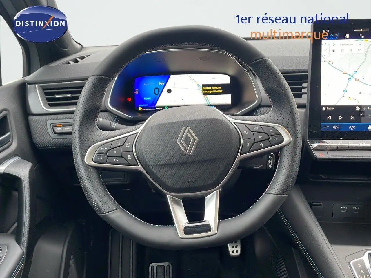 Vue rapprochée du volant noir perforé et du tableau de bord numérique de la Renault Symbioz hybride 2025.